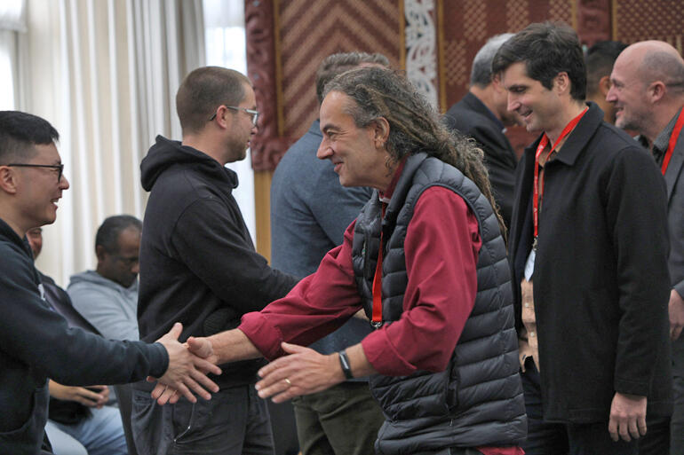 Rev Wilson Chan shakes hands with Archbishop Justin Duckworth in the Ethical Investment Summit hongi line ahead of Sam Inglis and Paul Gilberd.