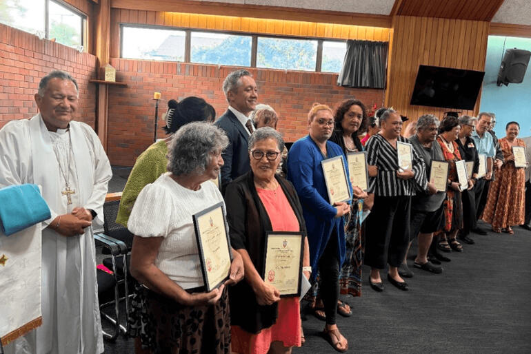 Orongonui graduates line up between Bishop Te Kitohi Pikaahu (L) and 2025 Dux Rona Eramiha (R).